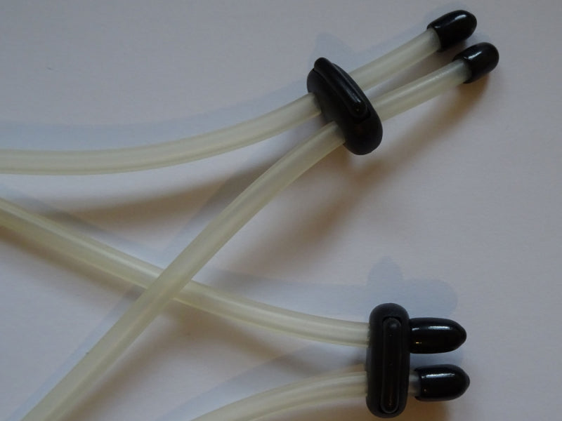 The ultimate breast bondage rings. Close-up – Transparent elastic straps with black clamps.